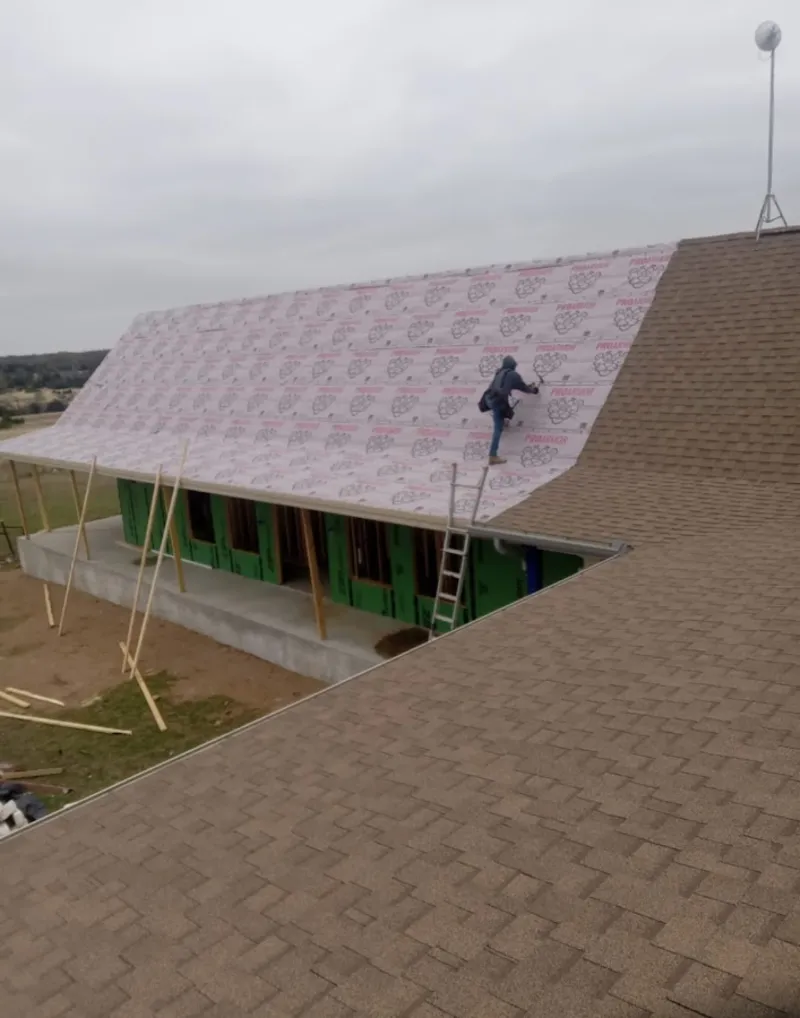 Worker preparing underlayment for a metal roof installation in Lake Morton-Berrydale